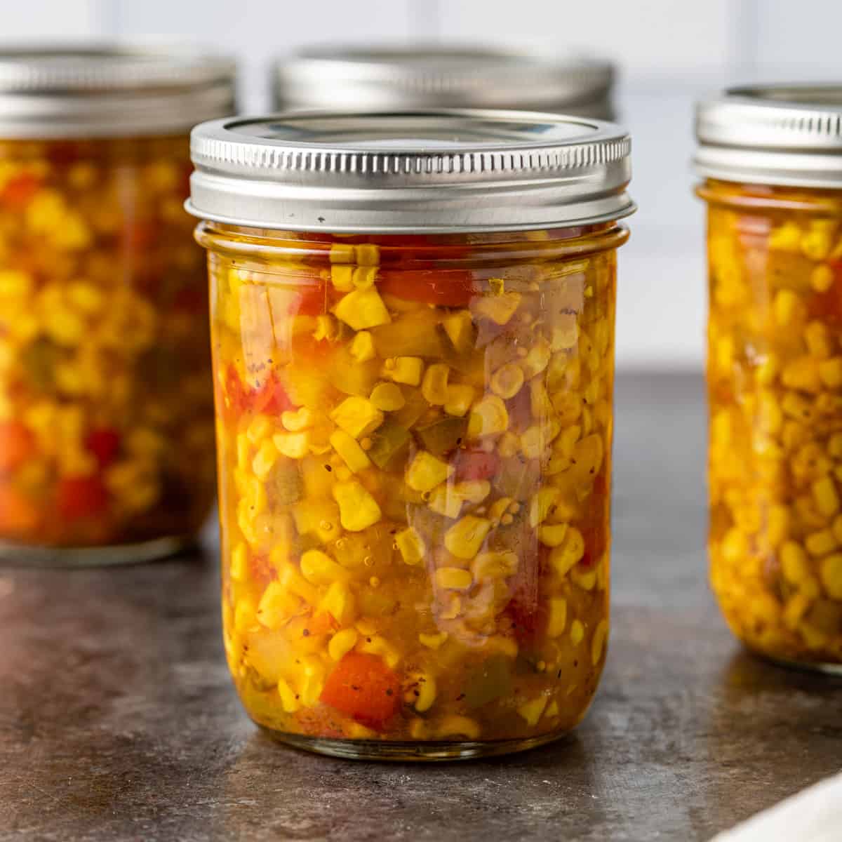 side view closeup: several mason jars full of Southern corn relish