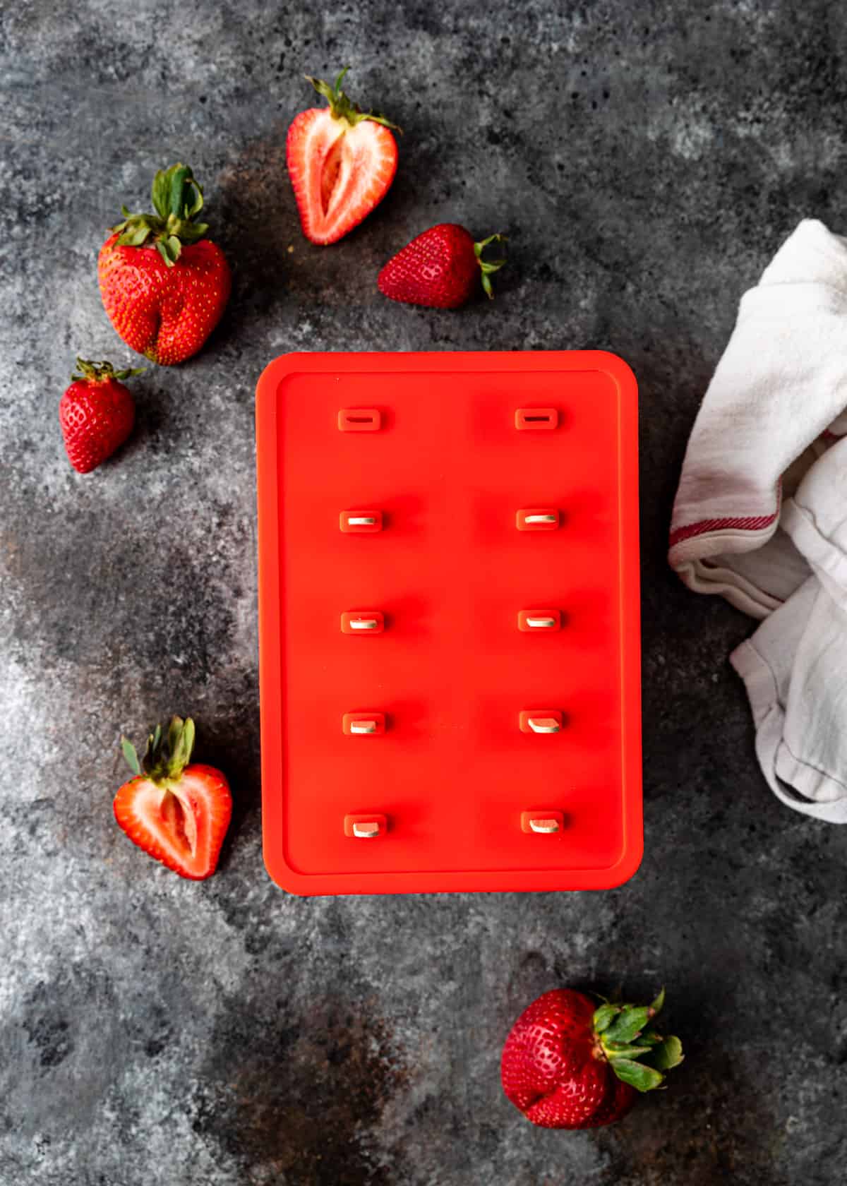 strawberries and cream ice pops in a red mold before freezing