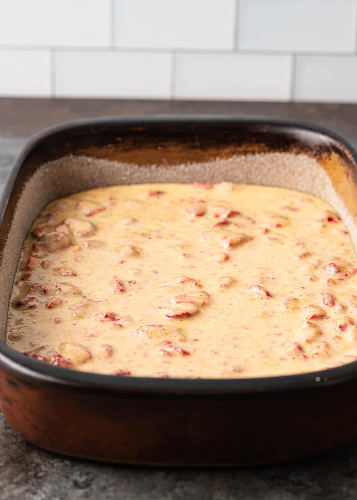 side view: cornmeal cake batter in a baking dish