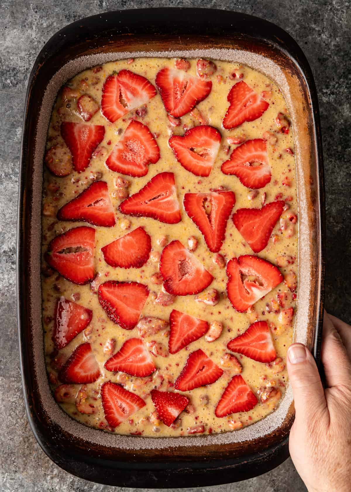 overhead: fresh cut strawberries on top of unbaked cornmeal cake