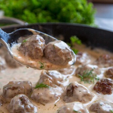 A close up of a plate of fSaucy swedish Meatball