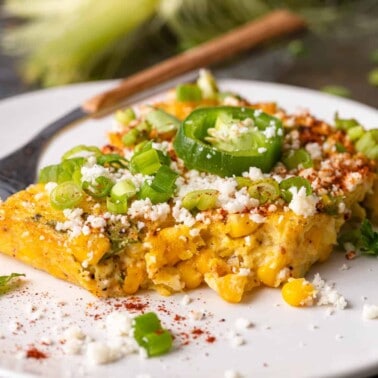 plated slice of Tex Mex cornbread pudding topped with scallions and Cojita cheese