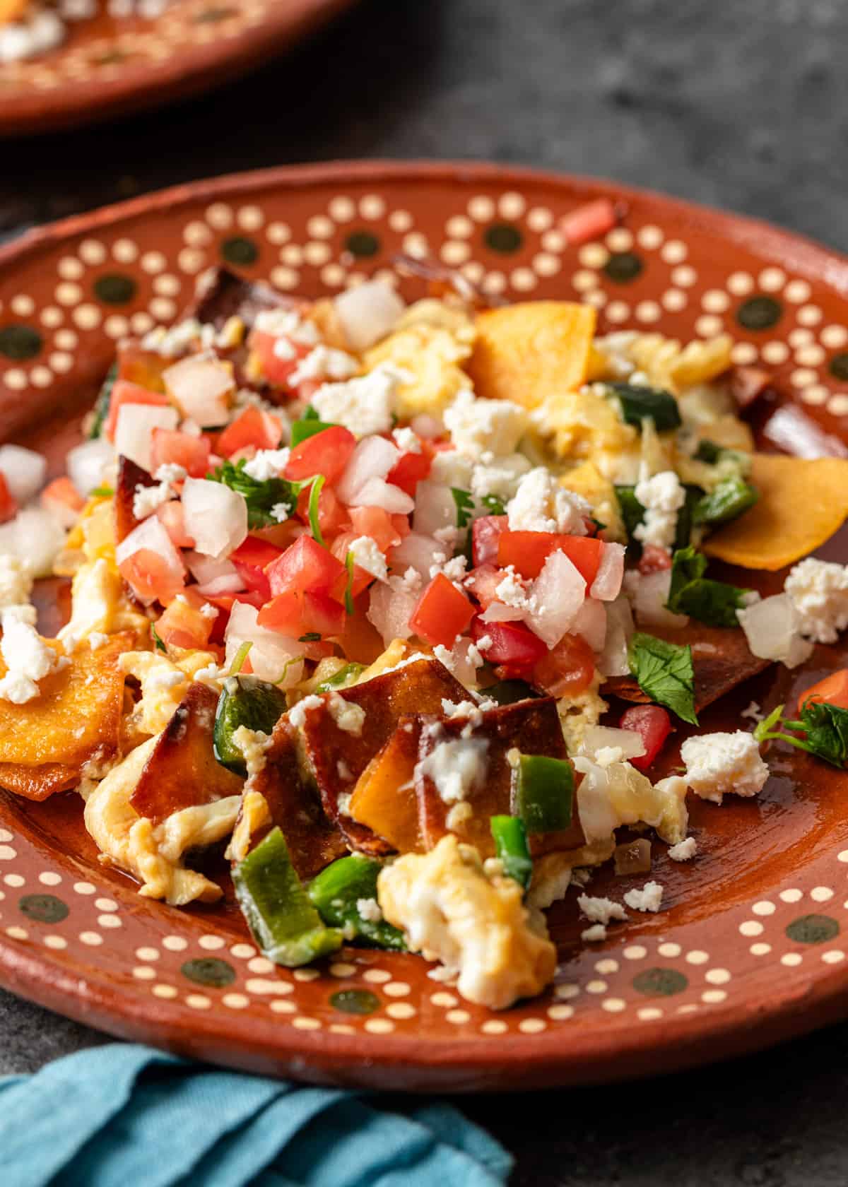 a plate of migas with pico de gallo and fresh cheese on top