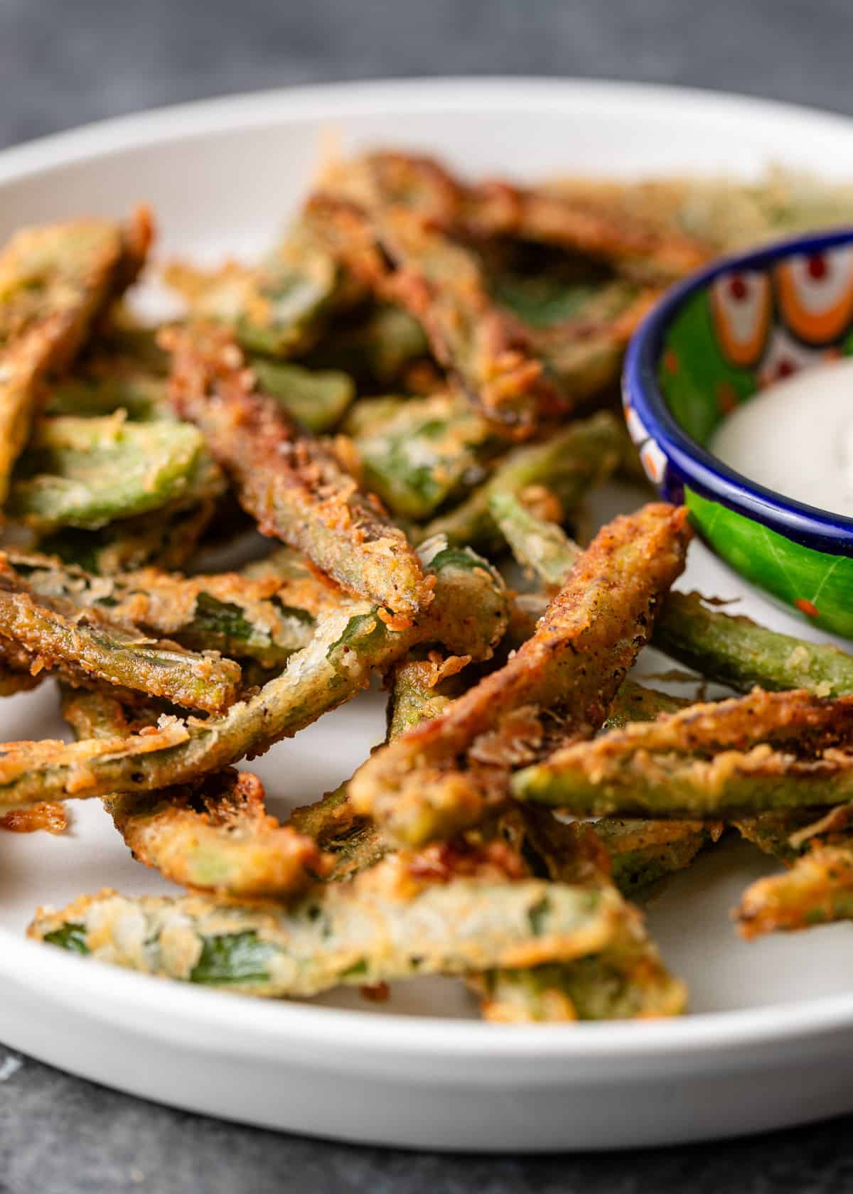 closeup: Texas toothpicks on a white plate with a side of dipping sauce