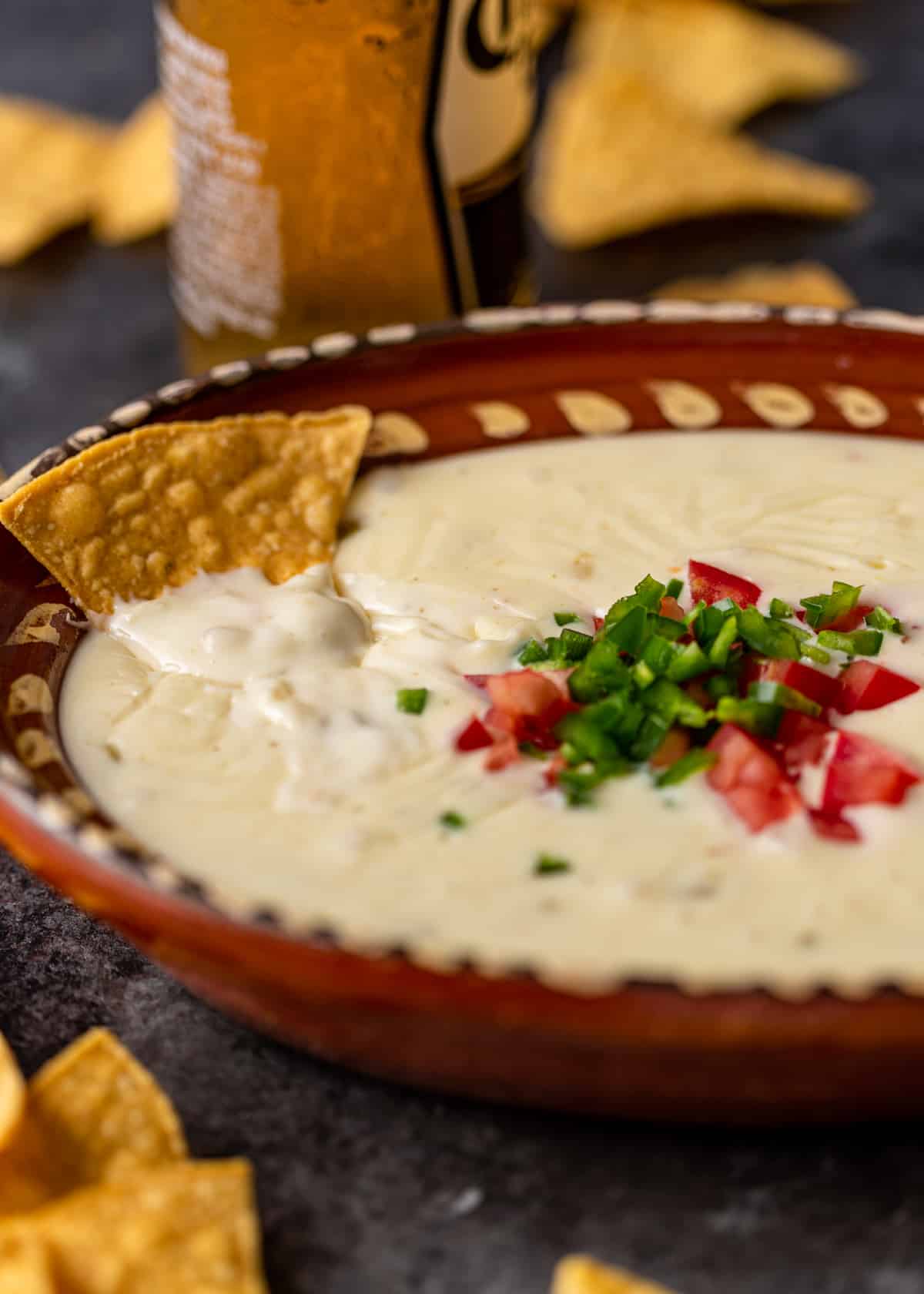 bowl of white queso blanco topped with diced tomato and chiles