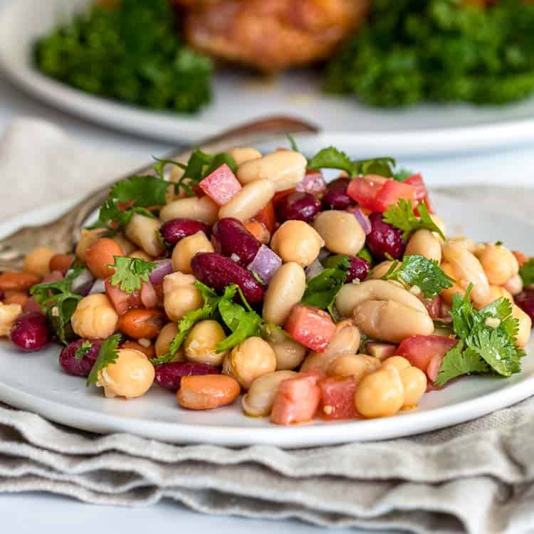 cold 4 bean salad with spicy vinaigrette on white plate